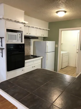 a kitchen with stainless steel appliances kitchen island granite countertop a refrigerator and a stove top oven