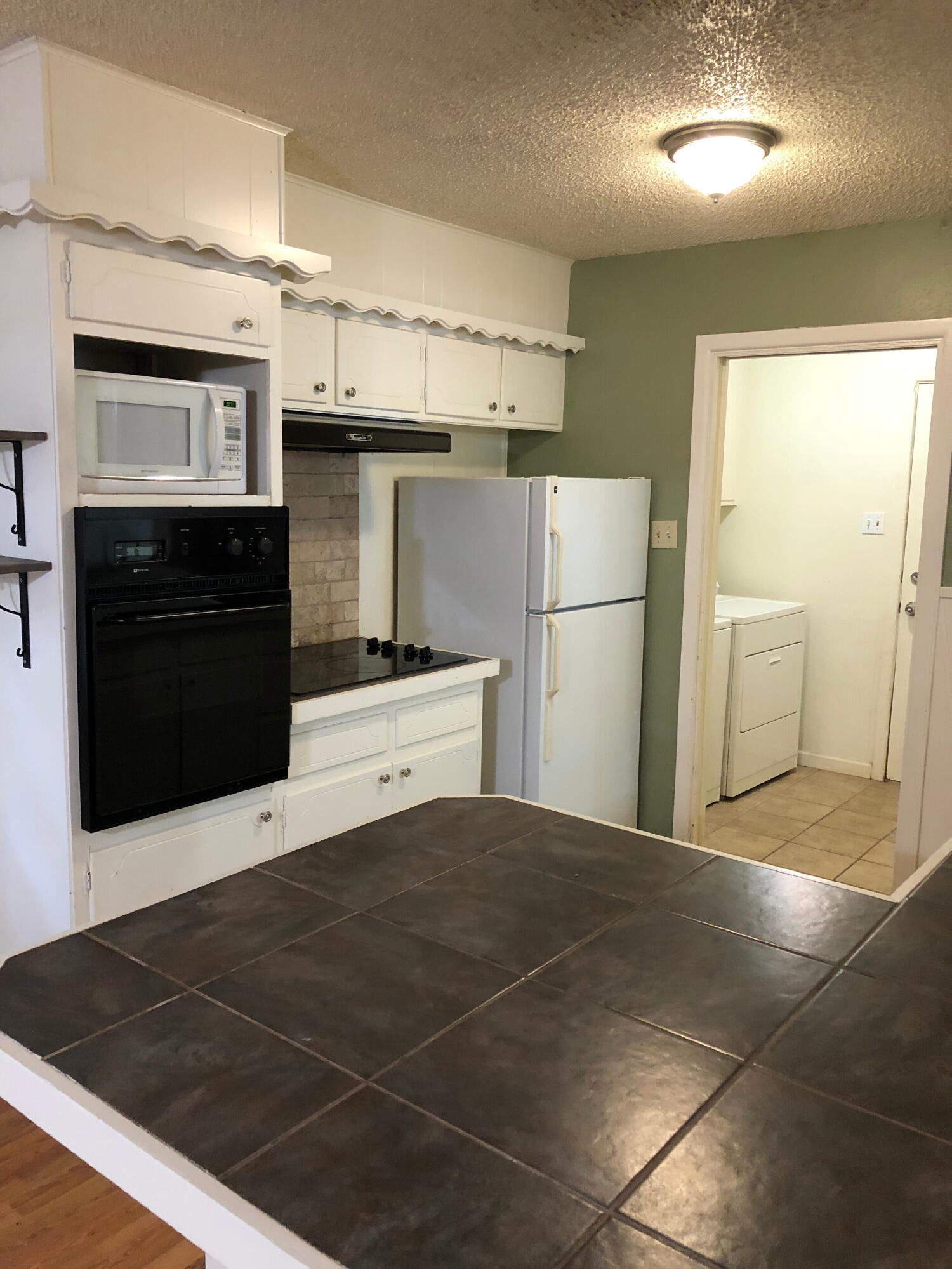 3020 45th Street Lubbock, TX 79413 - Photo 6 of 20 a kitchen with stainless steel appliances kitchen island granite countertop a refrigerator and a stove top oven