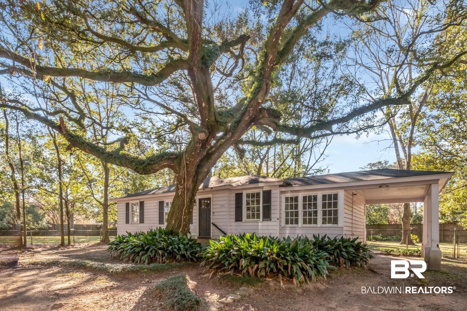 Single story home featuring fence and an attached carport