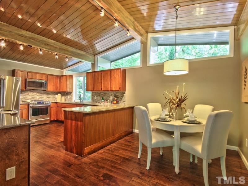 3005 Sandia Drive Raleigh, NC 27607 - Photo 3 of 25 a kitchen with stainless steel appliances granite countertop a table chairs and a wooden floors