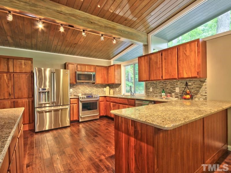 3005 Sandia Drive Raleigh, NC 27607 - Photo 5 of 25 a kitchen with stainless steel appliances granite countertop a stove a sink dishwasher and a refrigerator