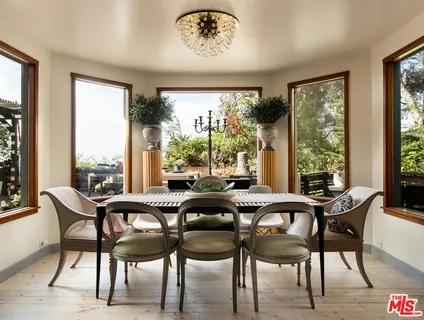 a dining room with furniture and large windows