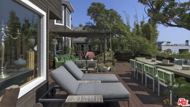 a view of a patio with couches table and chairs and potted plants