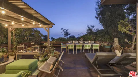 a view of a patio with couches table and chairs and potted plants