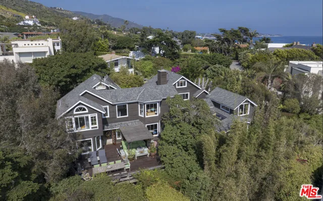 an aerial view of a house with large trees