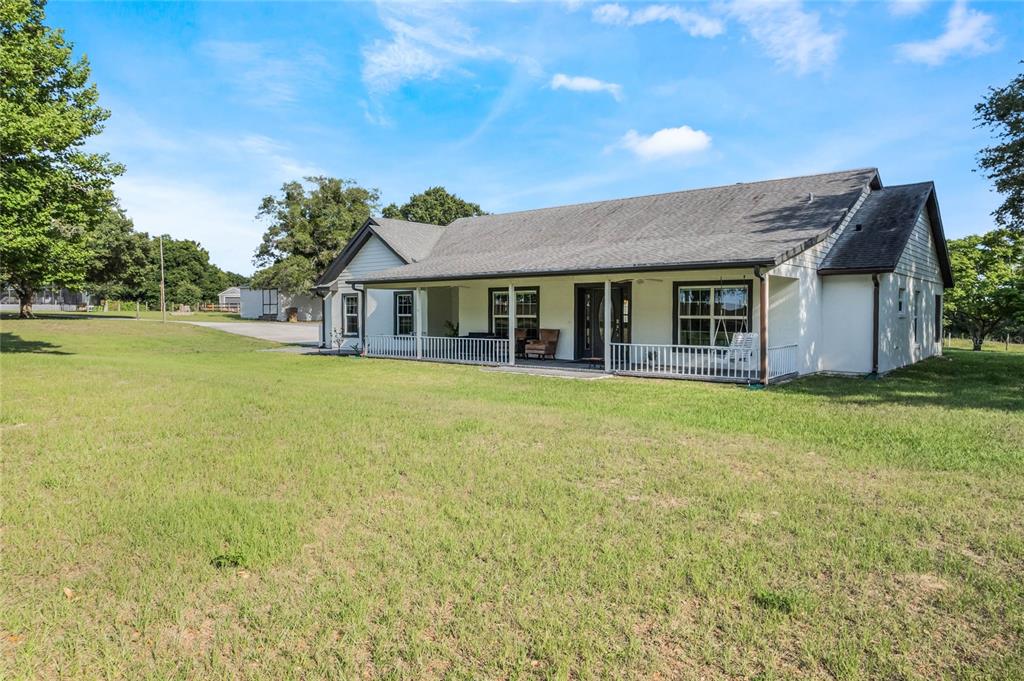 10311 Dog Patch Lane Clermont, FL 34715 - Photo 1 of 1 a front view of a house with yard and glass top table and chair