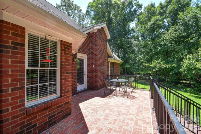 a view of a patio with table and chairs with wooden floor and fence