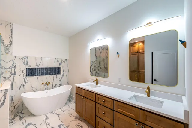 a bathroom with double vanity sinks and a mirror