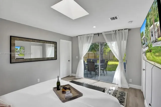 a large white bedroom with a bed and a large window