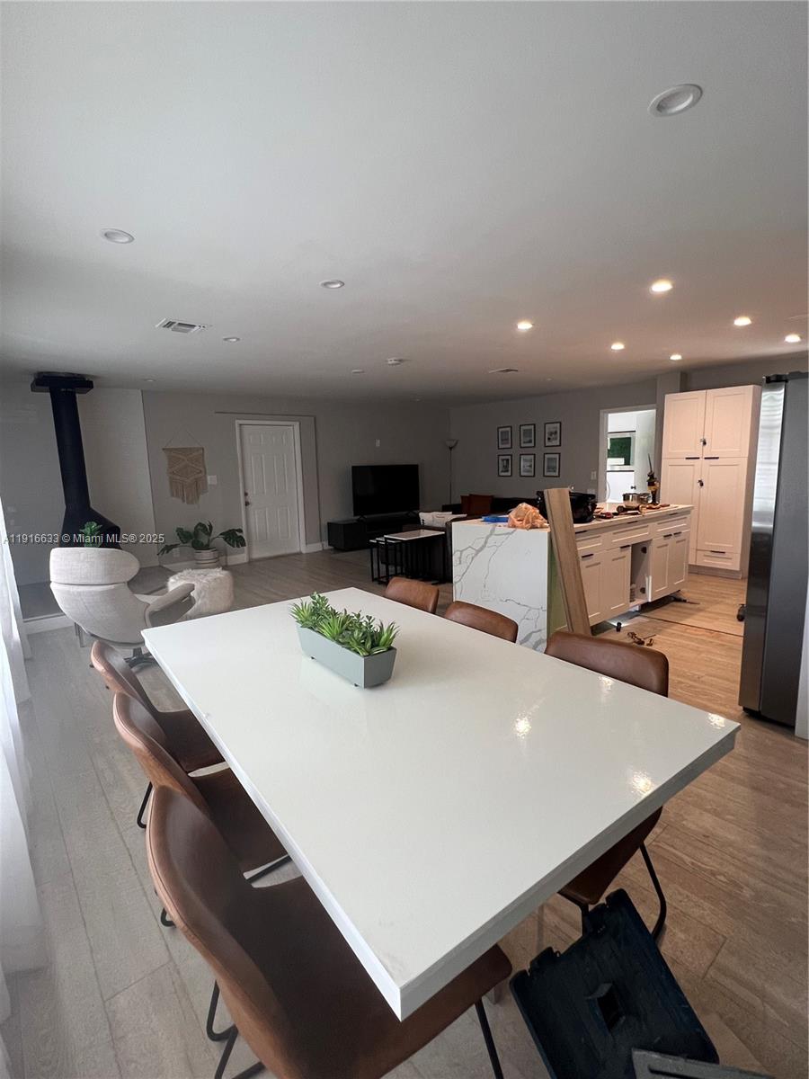 1573 Northeast 30th Court Pompano Beach, FL 33064 - Photo 21 of 27 a kitchen with stainless steel appliances a stove a table and chairs