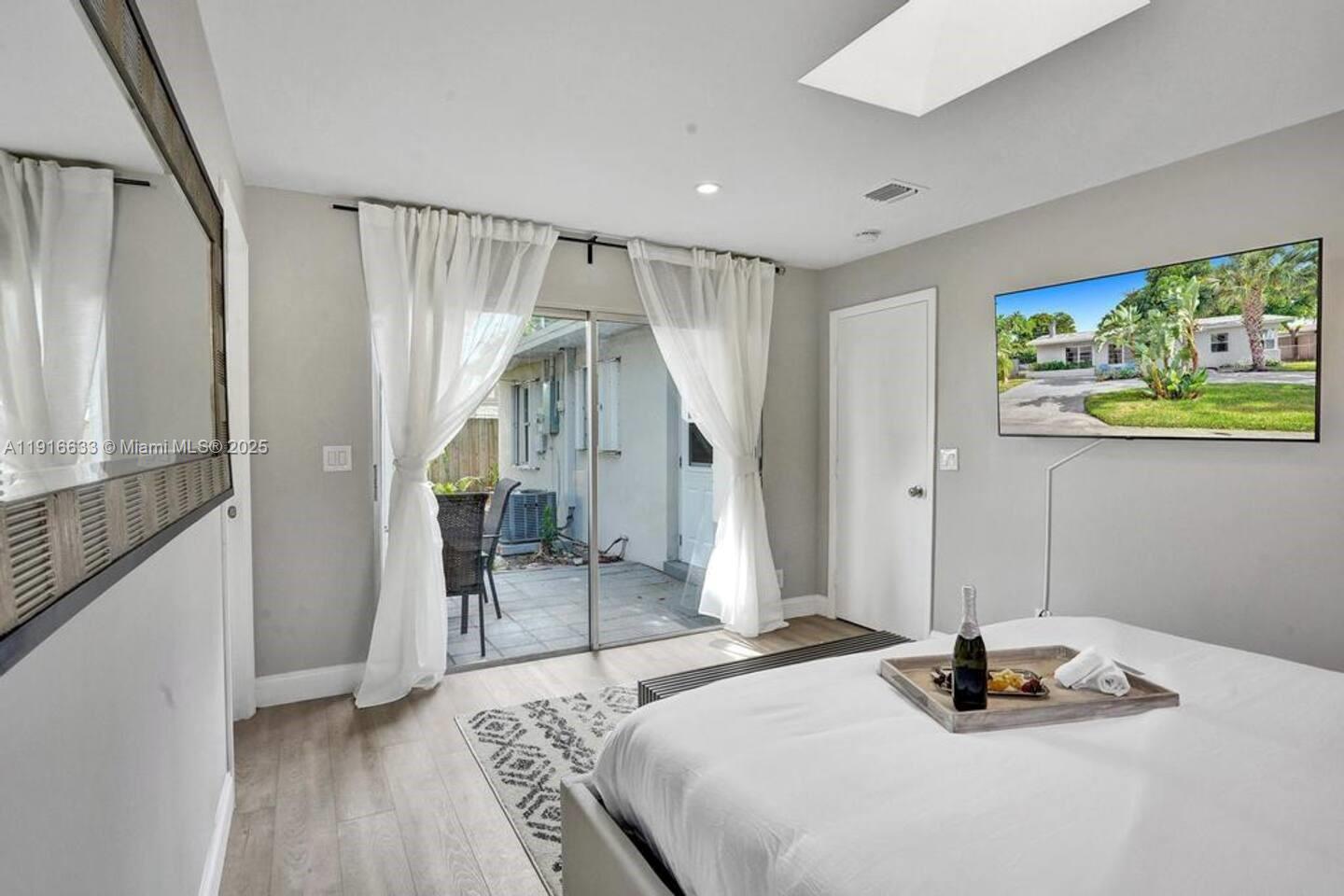 1573 Northeast 30th Court Pompano Beach, FL 33064 - Photo 7 of 27 a bedroom with a bed and a mirror