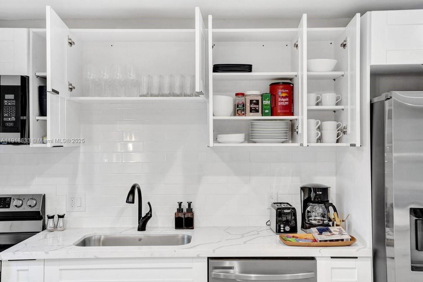 1573 Northeast 30th Court Pompano Beach, FL 33064 - Photo 10 of 27 a kitchen with a refrigerator and cabinets