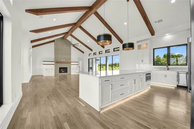 a kitchen with stainless steel appliances kitchen island wooden floors and white cabinets