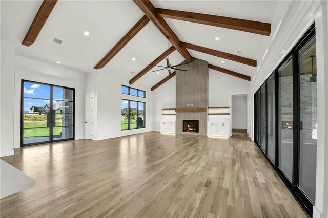 a view of empty room with wooden floor and fireplace