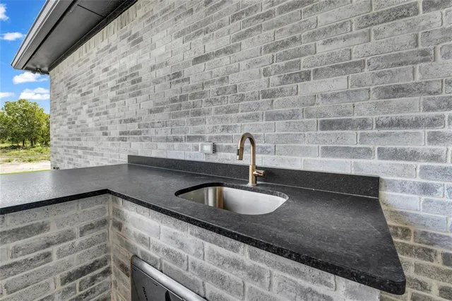 a kitchen with granite countertop a sink and a wooden floor