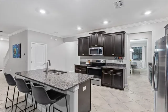 a kitchen with granite countertop a center island and stainless steel appliances