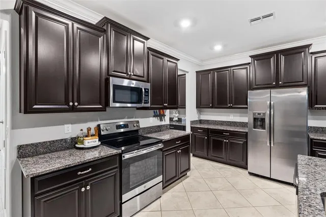 a kitchen with granite countertop stainless steel appliances and wooden cabinets