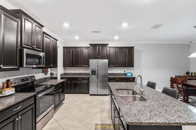 a kitchen with granite countertop a stove sink and microwave