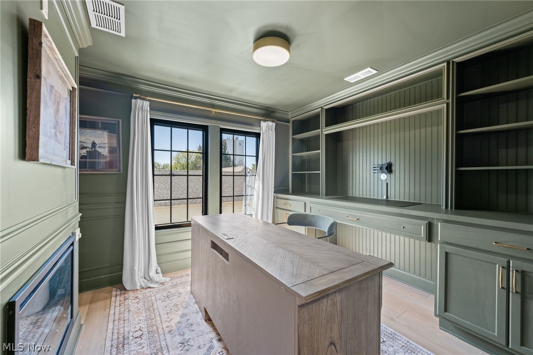 25870 Kennedy Ridge Road North Olmsted, OH 44070 - Photo 28 of 50 Built-in cabinetry with shelving and beadboard backing, double casement windows with dark frames, light wood-finish flooring, and a contemporary ceiling light fixture