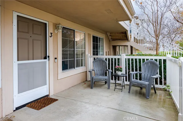a view of a house with a chairs and table in a patio