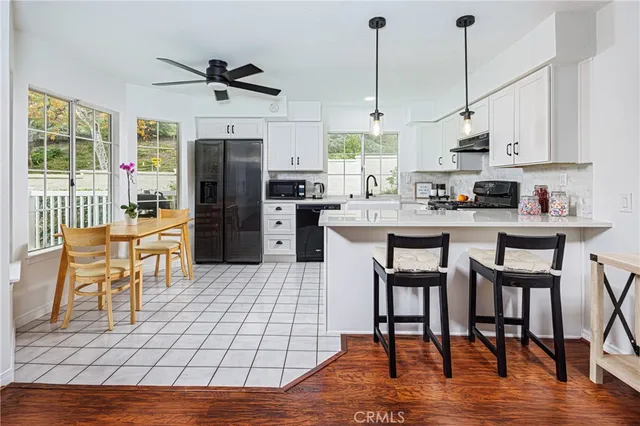 a kitchen with stainless steel appliances kitchen island granite countertop a table chairs and a refrigerator
