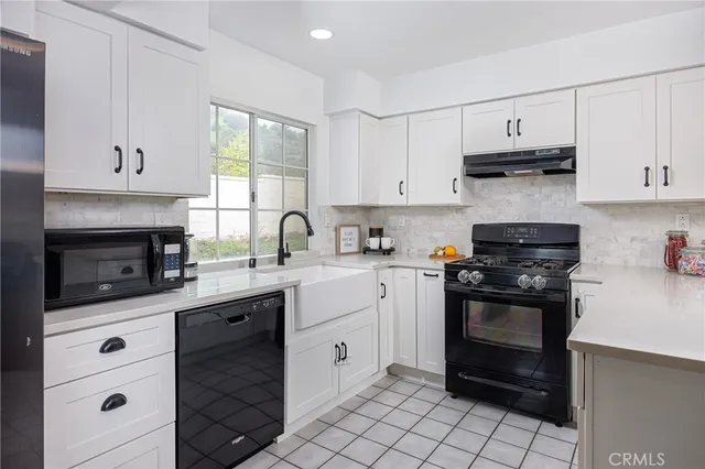 a kitchen with cabinets appliances a sink and a window