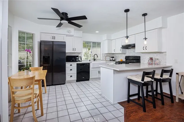 a kitchen with stainless steel appliances granite countertop a stove a sink dishwasher a refrigerator with a dining table and chairs