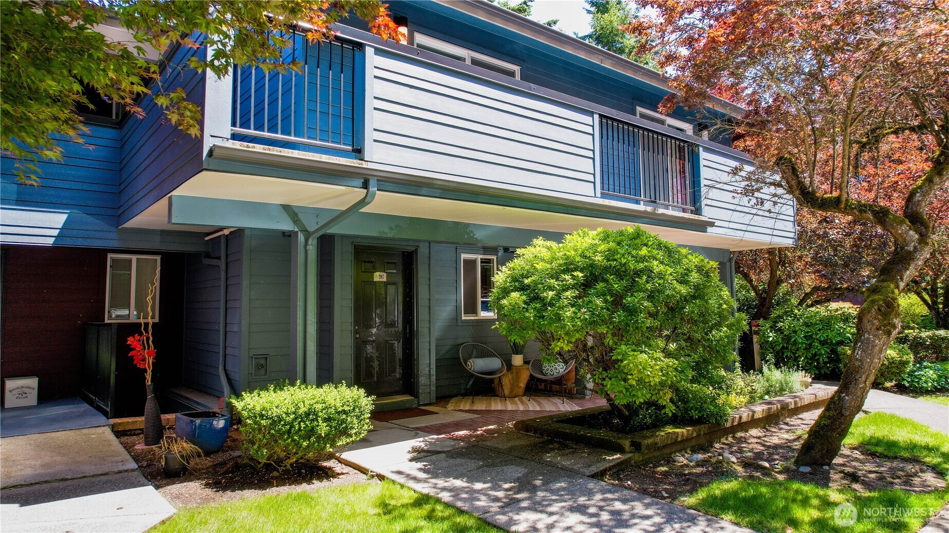 a view of a house with potted plants and a table and chairs