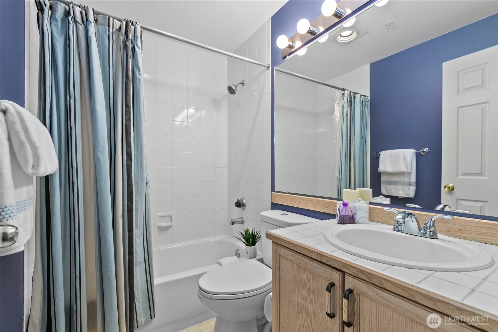 16019 Waynita Way Northeast, Unit F207 Bothell, WA 98011 - Photo 25 of 39 a bathroom with a sink a toilet a mirror and shower