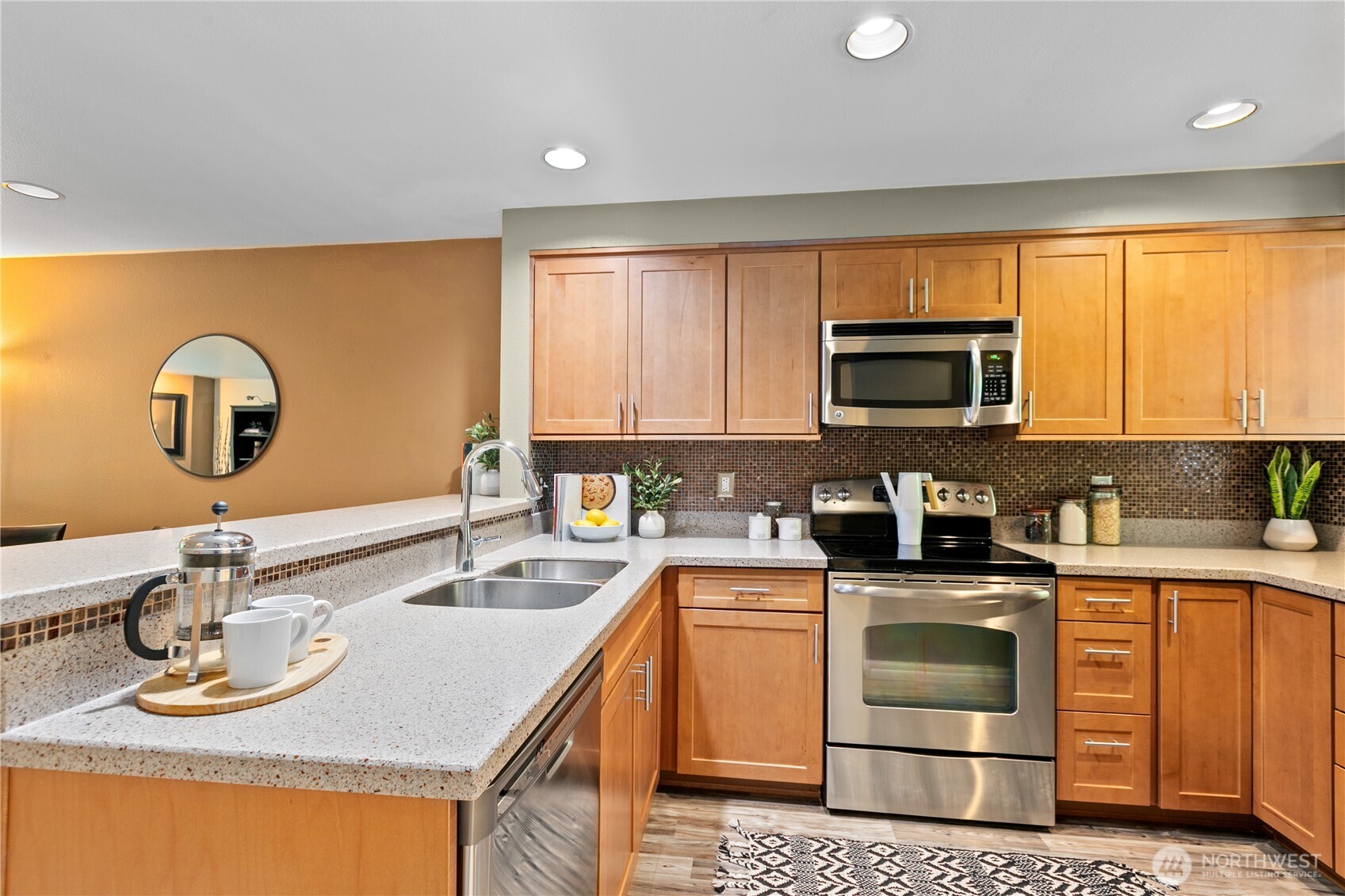 16019 Waynita Way Northeast, Unit F207 Bothell, WA 98011 - Photo 4 of 39 a kitchen with kitchen island granite countertop a sink appliances cabinets and a counter top space
