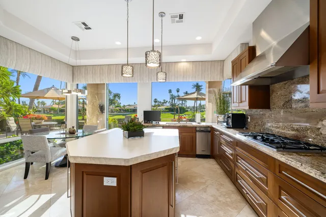 a kitchen with a sink a stove and chairs