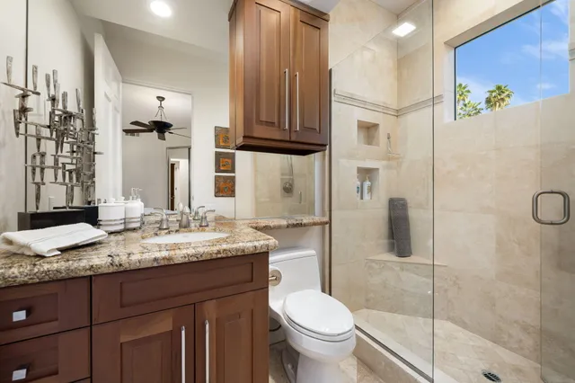 a bathroom with a granite countertop sink toilet and shower