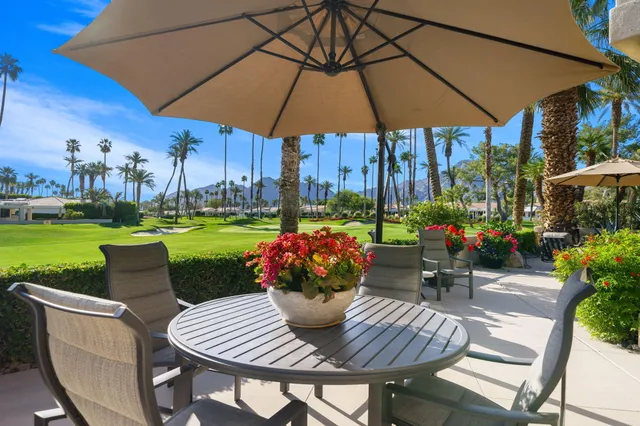 a view of a patio with a table chairs and a umbrella