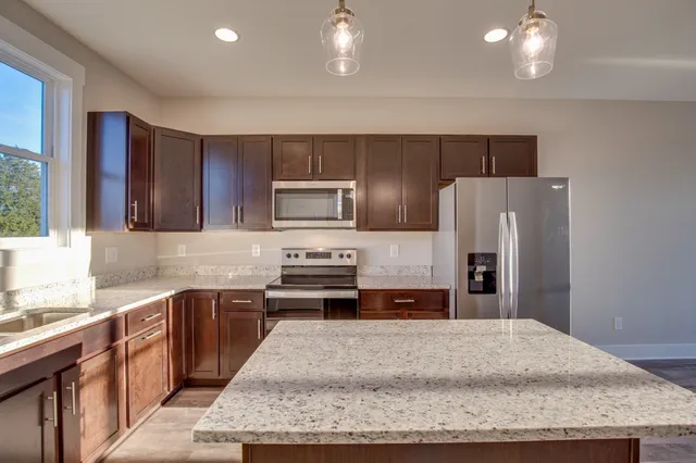 a kitchen with stainless steel appliances granite countertop a sink stove and refrigerator