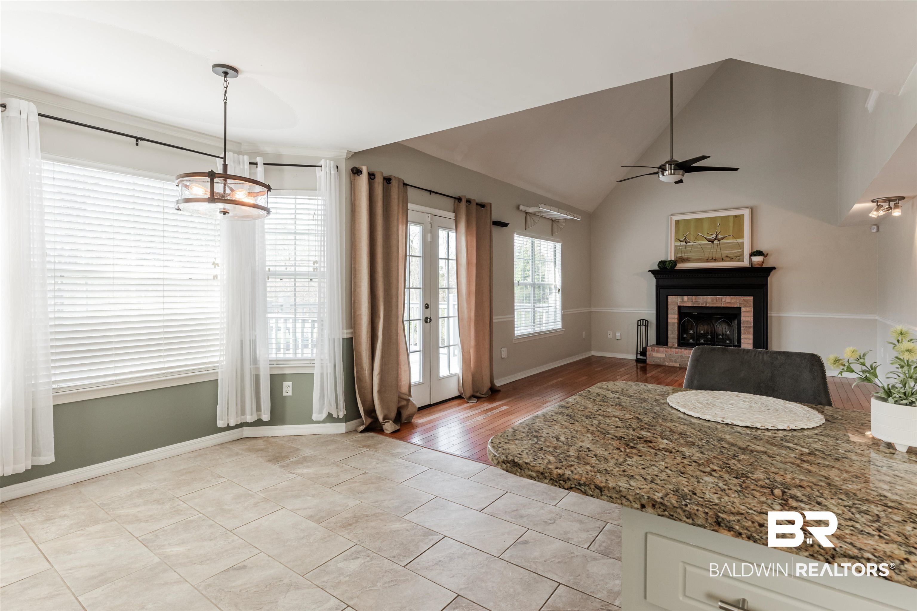 3844 Isabel Way South Mobile, AL 36693 - Photo 14 of 49 Unfurnished living room featuring french doors, vaulted ceiling, a brick fireplace, light tile patterned floors, and ceiling fan