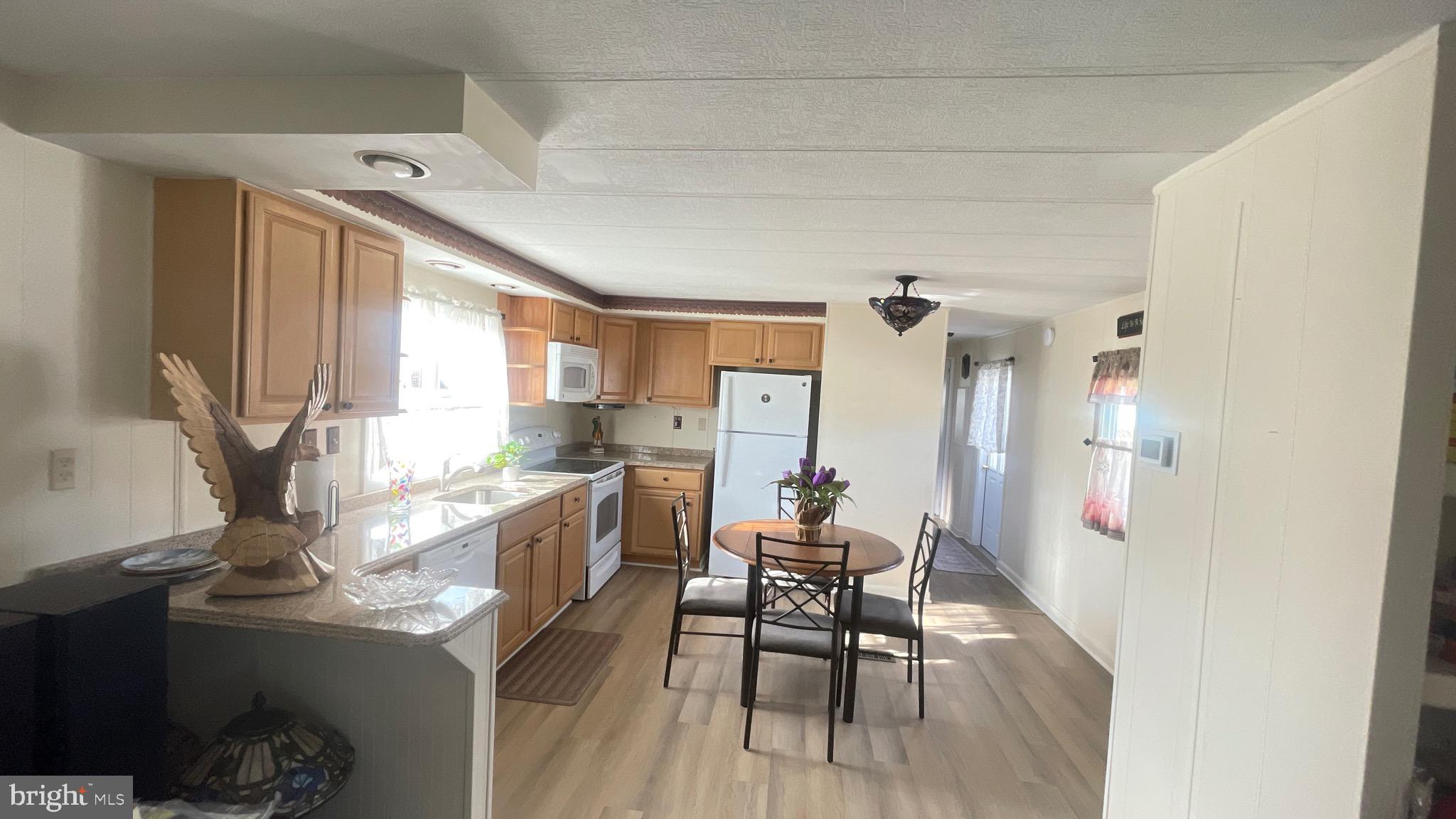 461 Running Brook Road North Wales, PA 19454 - Photo 14 of 19 a kitchen with stainless steel appliances kitchen island granite countertop a table chairs in it and wooden floors