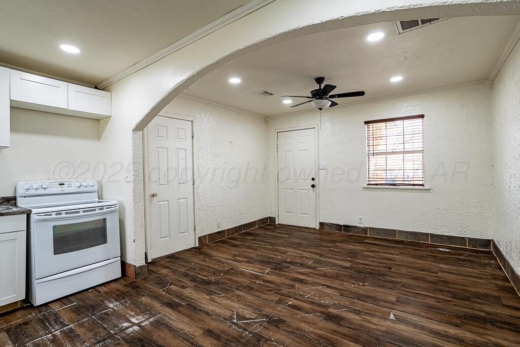 2501 Spruce Street Amarillo, TX 79103 - Photo 4 of 15 an empty room with a fireplace a ceiling fan and wooden floor