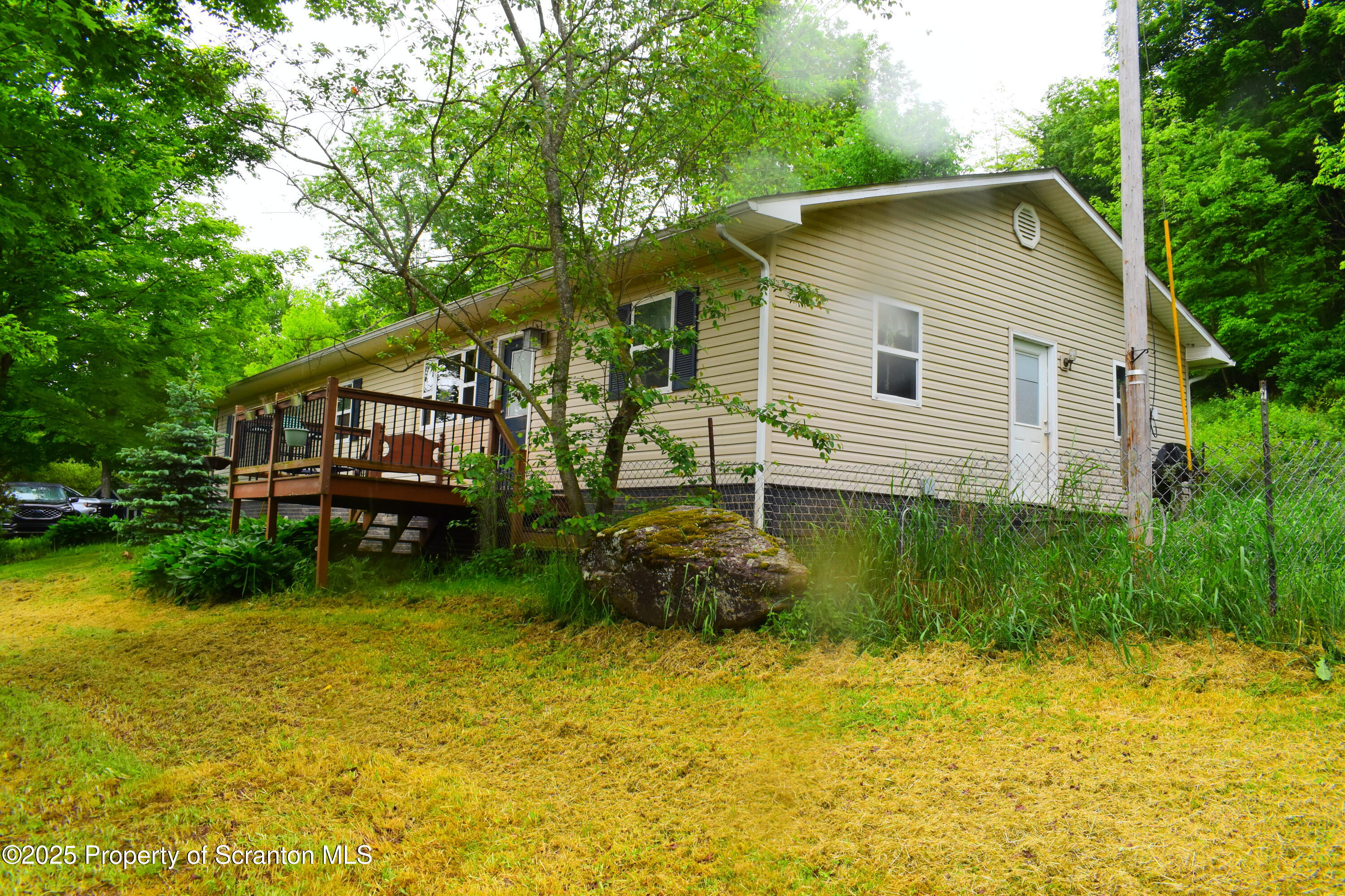 760 State Rte 3021 Springville, PA 18844 - Photo 6 of 26 a backyard of a house with plants and large trees with wooden fence