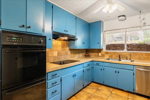 a kitchen with stainless steel appliances granite countertop a sink a stove and cabinets