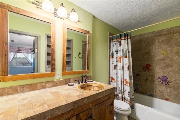 a bathroom with a sink vanity granite toilet tub and shower