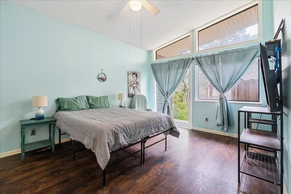 a bedroom with a bed a table and flat screen tv