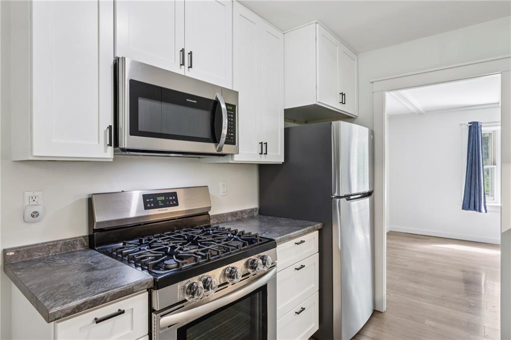 3425 Mercer Road New Castle, PA 16105 - Photo 8 of 38 a kitchen with stainless steel appliances granite countertop a stove microwave refrigerator and sink