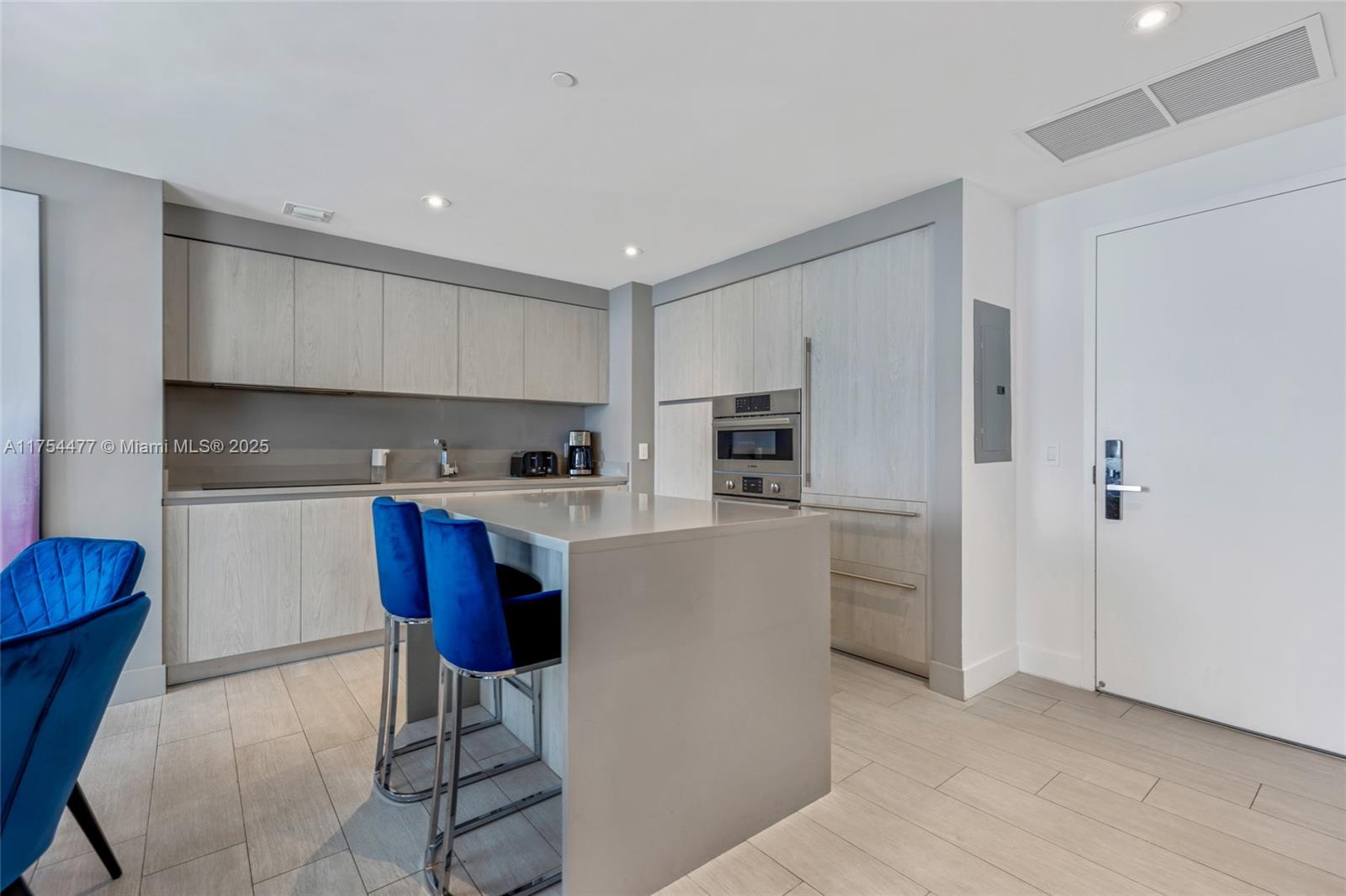 4010 South Ocean Drive, Unit R2505 Hollywood, FL 33019 - Photo 16 of 29 a kitchen with stainless steel appliances kitchen island granite countertop a refrigerator a stove a sink and white cabinets with wooden floor