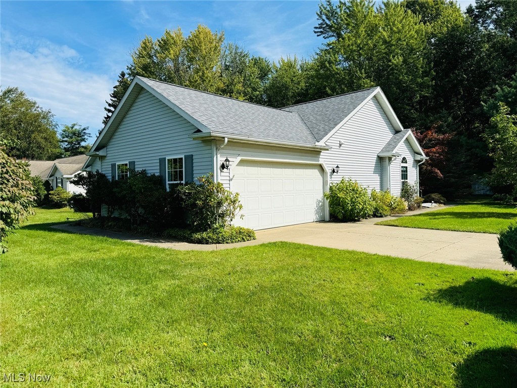 1467 Bennett Road Madison, OH 44057 - Photo 3 of 26 View of home's exterior with a garage and a lawn