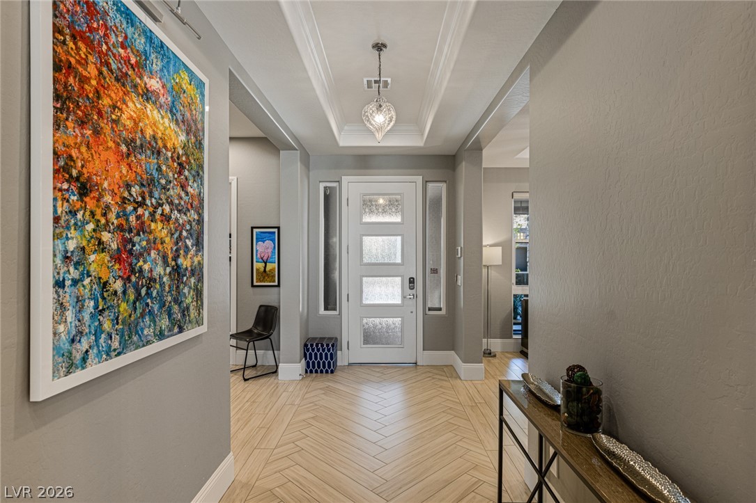 10118 Copper Edge Road Las Vegas, NV 89148 - Photo 3 of 48 Herringbone-patterned flooring introduces an inviting entry, crowned by a tray ceiling and a sparkling chandelier.