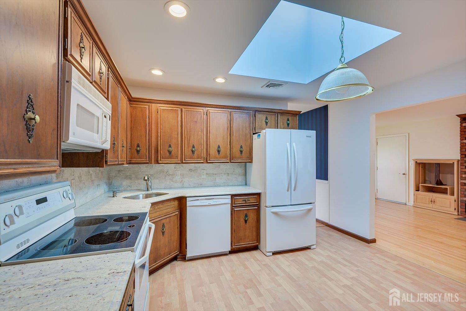 17 Bartha Avenue Edison, NJ 08817 - Photo 11 of 25 a kitchen with stainless steel appliances granite countertop a refrigerator a sink dishwasher a stove and white countertops with wooden floor