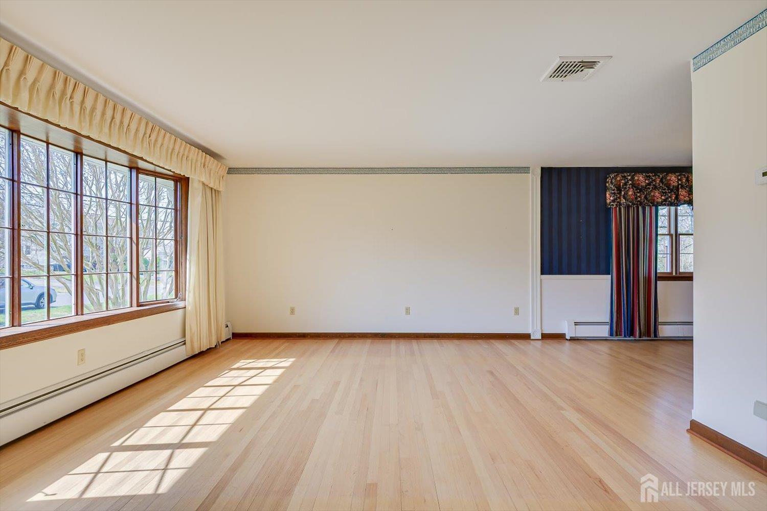 17 Bartha Avenue Edison, NJ 08817 - Photo 5 of 25 an empty room with wooden floor and windows