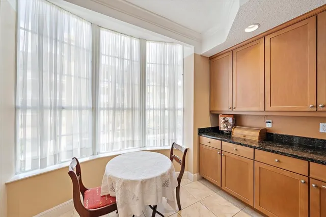 a kitchen with stainless steel appliances granite countertop a stove top oven a sink a dining table and chairs with wooden floor