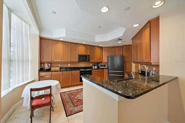 a kitchen with stainless steel appliances granite countertop a refrigerator a stove a sink and dishwasher