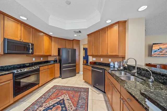 a kitchen with stainless steel appliances granite countertop a sink stove microwave refrigerator and cabinets